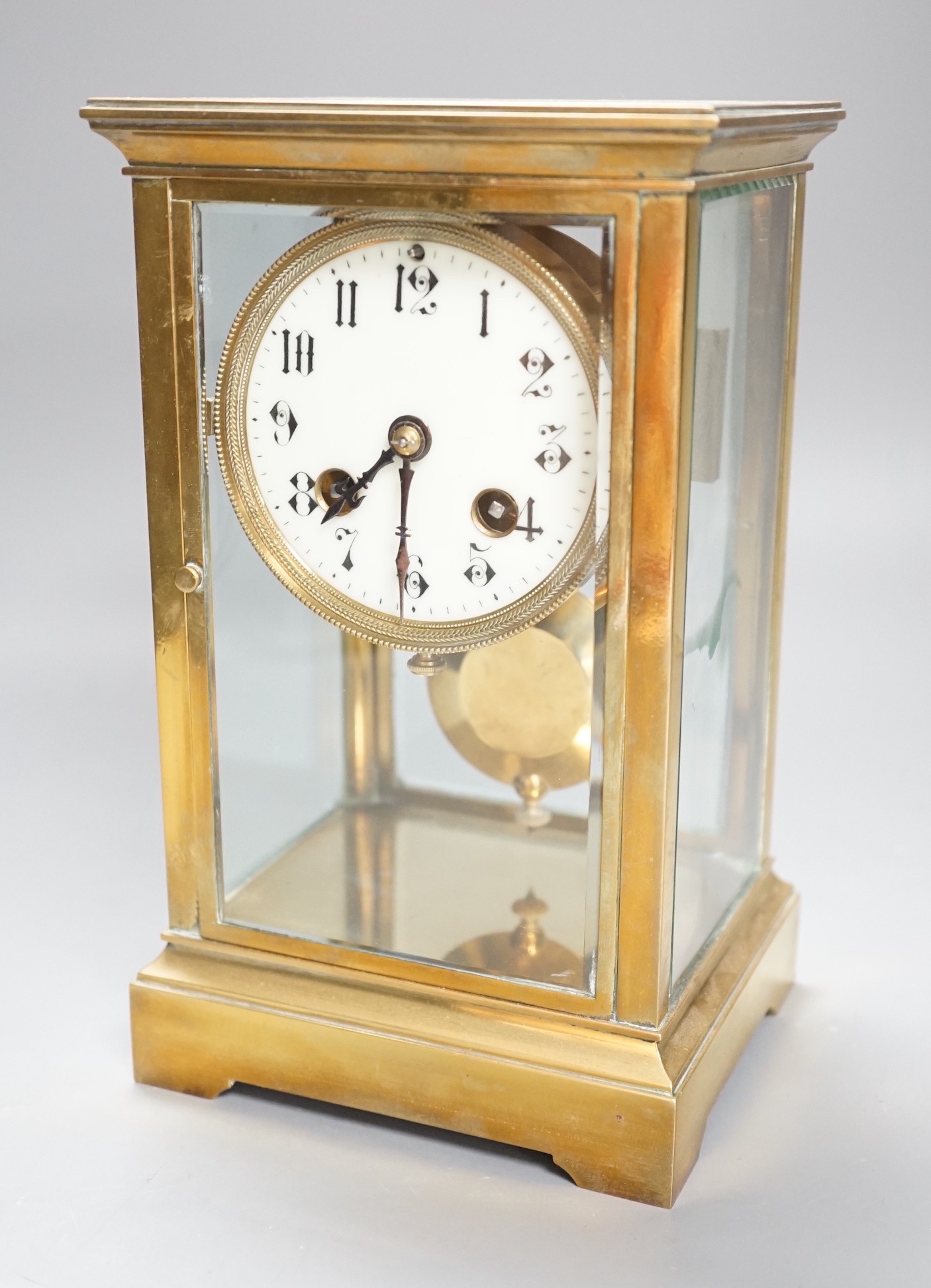 A French brass four glass mantel clock, 23cms high